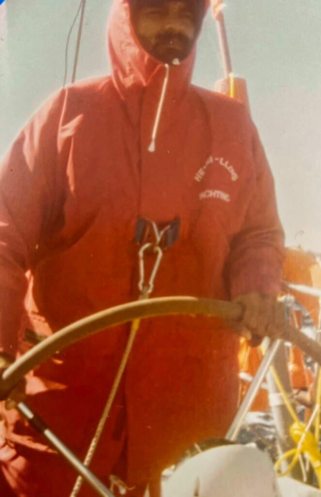 Fully buttoned up in heavy weather clothing, with life-line attached to the boat to prevent being washed overboard in the huge waves