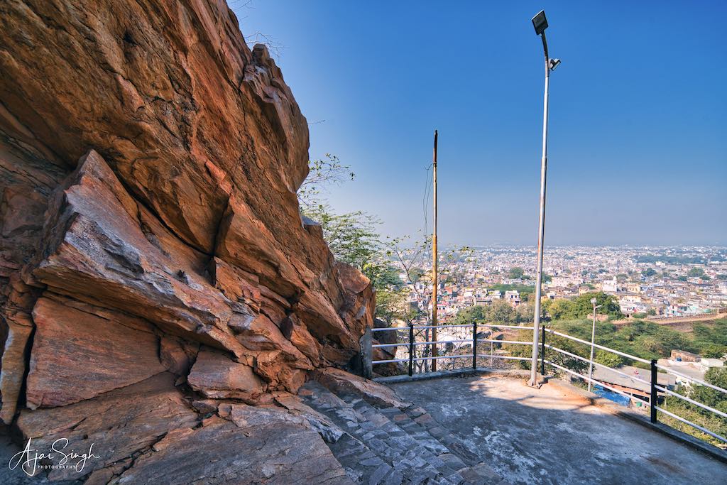 A wide ramp, railings and street lights along the way up the hill to the temple