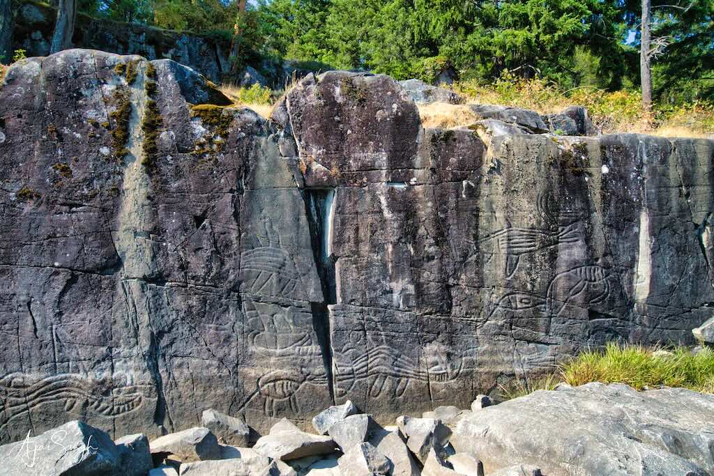 The petroglyphs, also called "K’ak’awin", on the lakeshore rocks depict mythological figures